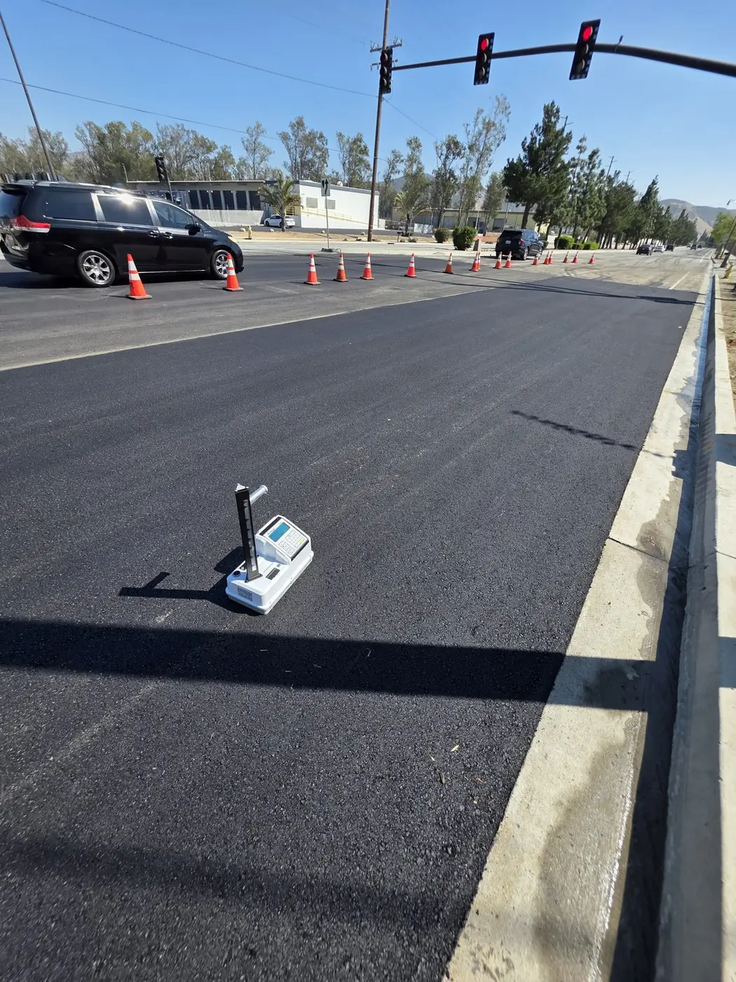 NGS white Troxler 4540 nuclear density gauge during asphalt compaction testing in Fontana
